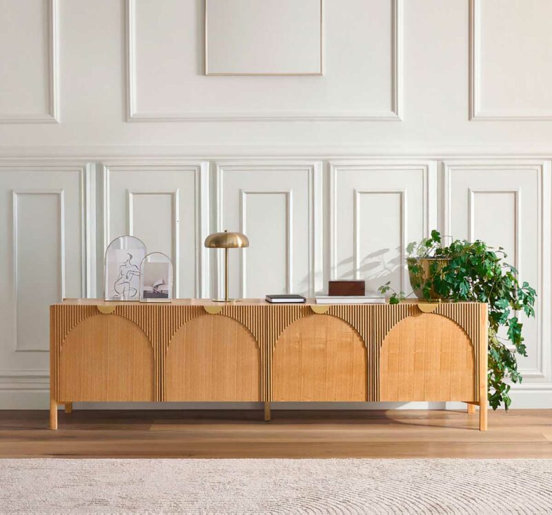 Portes arquées et détails dorés pour un meuble TV en bois clair