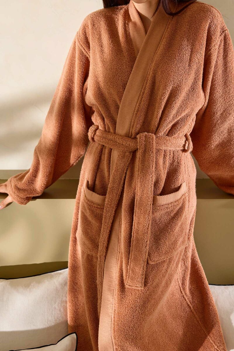 Femme portant le peignoir kimono Narumi Madura en terre d'argile, coupe fluide et élégante